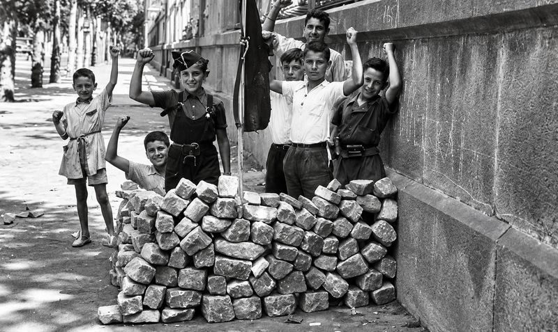 Nens darrere d'una barricada improvisada al costat de la Universitat de Barcelona, l'agost de 1936. Fotografia d'Antoni Campañà.