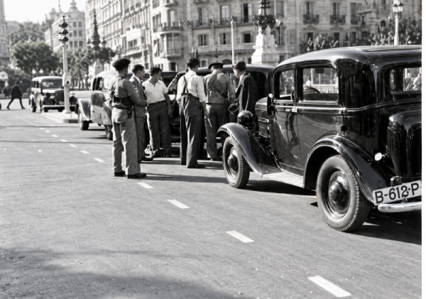 Patrulla de control aturant un vehicle en un carrer de Barcelona durant la Guerra Civil.